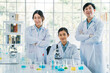 © twinsterphoto - Portrait of successful team of male and female Asian medical researcher and scientist working in medical lab wearing labcoat looking at camera with crossed arms