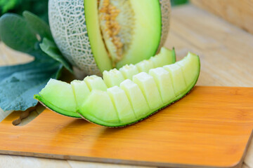 Closeup to Fresh green melon on wood plate