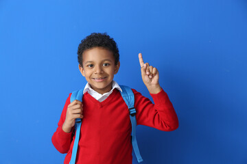 Canvas Print - Little African-American schoolboy with raised index finger on color background