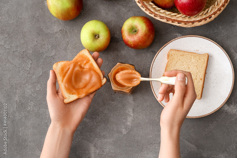 Woman and toasts with sweet apple jam on dark background