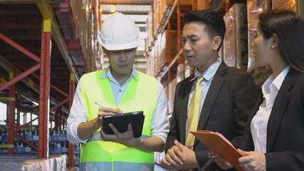 Wall Mural - Asian male foreman or manager showing report from digital tablet to business man and woman or CEO in warehouse company. people discuss of logistics shipping, quality control or export import goods.