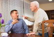 © JackF - Annoyed elderly man and his adult son having conflict at home