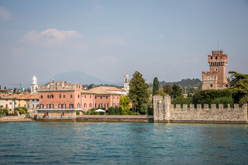 Wall Mural - View of Sirmione from Lake Garda. Autumn sunny evening. Sirmione, Lombardy, Italy