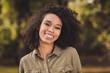 © deagreez - Photo of attractive carefree wavy hairdo dark skin lady toothy smile look camera enjoy weekend walking outdoors