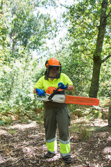 Sticker - female forestry worker or lumberjack using chainsaw to cut trees in forest