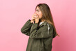 © luismolinero - Young woman over isolated pink background covering mouth and looking to the side