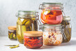 Homemade pickled or fermented vegetables in glass jars. Home preservation concept.