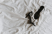 Flat Lay Of Black High-heels On White Crumpled Linen Cloth. Fashion Background.