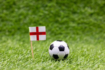 Soccer ball with England Flag on green grass background