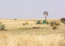 Water Reservoir Tanks With Windmill On Farm Land