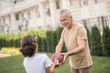 © zinkevych - Gray-haired dad giving a ball to his son and smiling