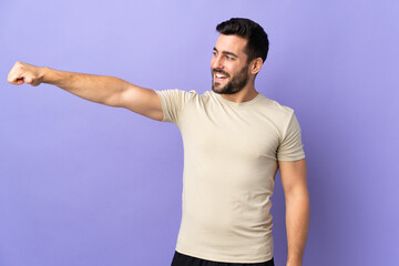 Wall Mural - Young handsome man with beard over isolated background giving a thumbs up gesture