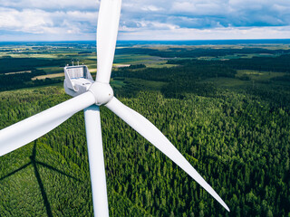 Wall Mural - Aerial view of windmills in green summer forest in Finland close up.