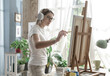 © StockPhotoPro - Woman listening to music and painting