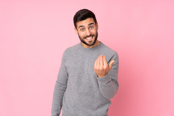 Canvas Print - Caucasian handsome man over isolated background inviting to come with hand. Happy that you came