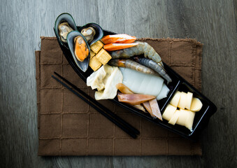 Wall Mural - fresh raw pork, meat ,beef, belly, sliced on square plate  on fabric and wood, wooden background, shabu, hot pot ingredients.