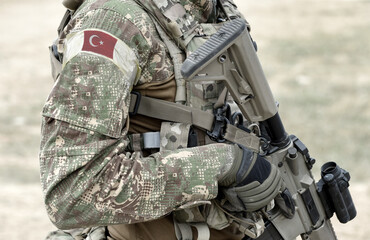 Soldier with assault rifle and flag of Turkey on military uniform. Collage.