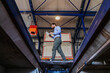 © Dusan Petkovic - Young bearded businessman holding tablet and walking in garage of shipping firm.