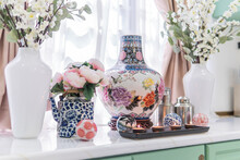 Closeup Of The Traditional Chinese Colorful Ceramic Vases With Flowers In The Kitchen With Candles
