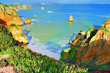 landscape of the beautiful Praia do Camilo beach, a sandy bay nestled between jagged cliffs, in Lagos in the Algarve region, Portugal