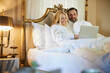 © Svitlana - Attractive lady and her boyfriend using laptop in bed