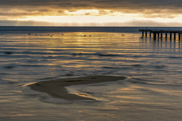 A sand bar with a beautiful ocean sunset in the background. Photo from Hallevik, Blekinge county, Sweden