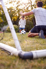 Father With Son Having Fun In Park Or Garden Playing Soccer Together