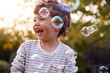 © Monkey Business - Young Boy Having Fun In Garden Chasing And Bursting Bubbles