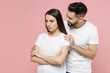 Young irritated offended sad couple two friends man woman in white basic t-shirts pout sulk sorry have problem stress need family psychologist isolated on pastel pink color background studio portrait.