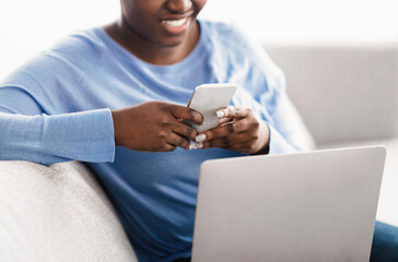 Closeup of smiling woman using smartphone at home