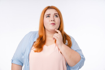 pensive young plump woman thinking in casual attire isolated over white background