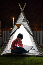 Little Kid Reading A Book On A Indian Tent At Night