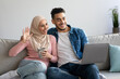 © Prostock-studio - Cheerful muslim couple having video conference with friends from home