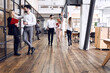 © Roman - On the way to business meeting. Full length of young modern people in formal wear having a discussion while walking through the office. A couple of freelancers are give five to each other