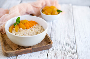 Wall Mural - Healthy breakfast of apricots oatmeal made with fresh fruit. Healthy eating food menu concept