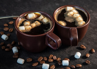 Wall Mural - Coffee in brown cups and marshmallows. Coffee break concept. Turkish coffee, marshmallows on a dark background. Close-up. Two cups of coffee with marshmallows, coffee beans