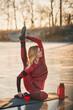 A girl does yoga in winter on the ice of the lake during the sunset