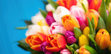 Fototapeta Tulipany - Colorful bouquet of tulips on blue wooden background. Spring tulip flowers. Greeting card with copy space for Valentine's Day, Woman's Day and Mother's Day.