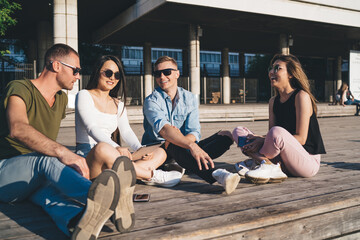 Wall Mural - Friends sitting outdoors together in summer sunlight