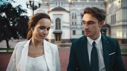 Charming business man and female professional talking about documents outdoors