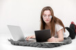 © Andriy Medvediuk - A seriously young girl in glasses sits with a laptop. Education, remote work and blogging. Isolated on a white background.