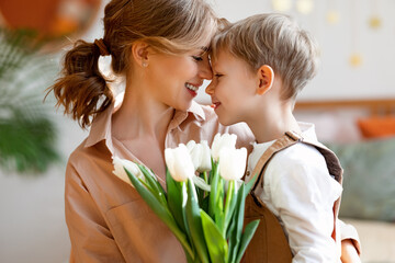 Wall Mural - happy woman and boy with flowers touching noses