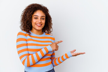 Wall Mural - Young african american woman isolated on white background excited holding a copy space on palm.