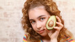 summer portrait of a young girl with beautiful skin, makeup and hairstyle and avocado