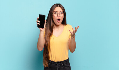 Wall Mural - young pretty woman feeling extremely shocked and surprised, anxious and panicking, with a stressed and horrified look