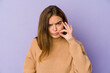 © Asier - Young skinny caucasian girl teenager on purple background with fingers on lips keeping a secret.