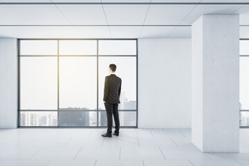 Aufkleber - Businessman looking out the window from modern room with light interior design