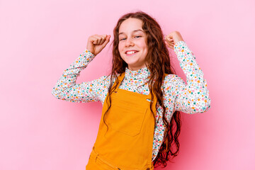 Wall Mural - Little caucasian girl isolated on pink background cheering carefree and excited. Victory concept.