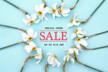 Wall Mural - Text Spring Sale. Special offer. 50% off. Round frame with spring flowers. Flowers Daffodils in form of wreath on blue background. Leaf pattern. Flat lay, top view.