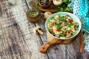 Diet food vegan concept. Vegan salad with couscous and champignons on a wooden table. Copy space.